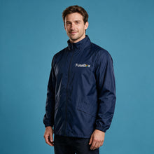 Load image into Gallery viewer, A man wearing a navy blue FuseBox lightweight jacket, standing against a solid blue studio background.
